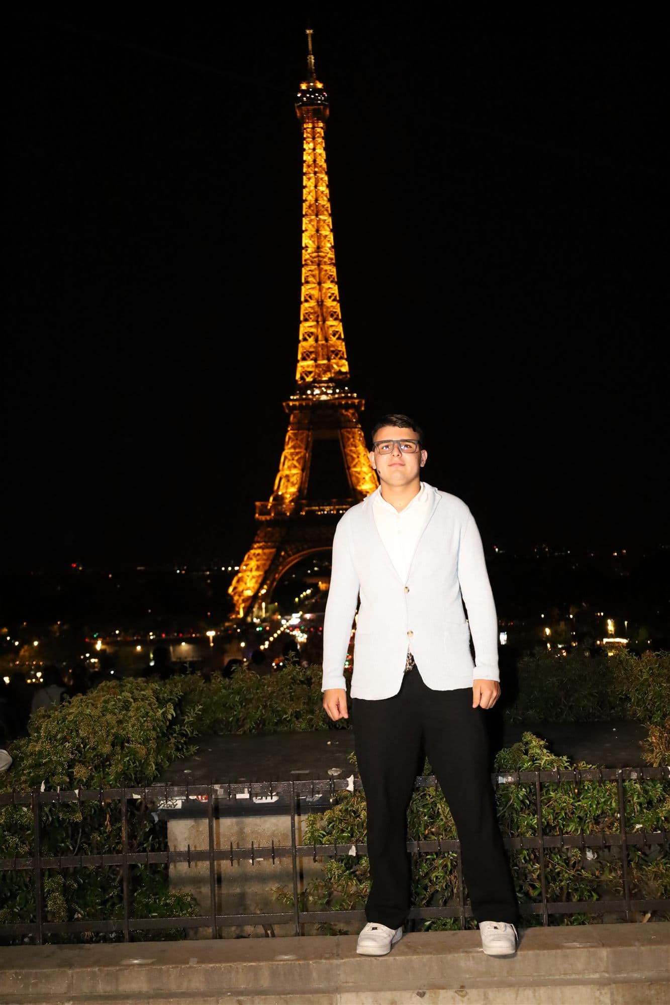 Gianmarco Pacetti di notte a Parigi, con la Tour Eiffel illuminata alle spalle
